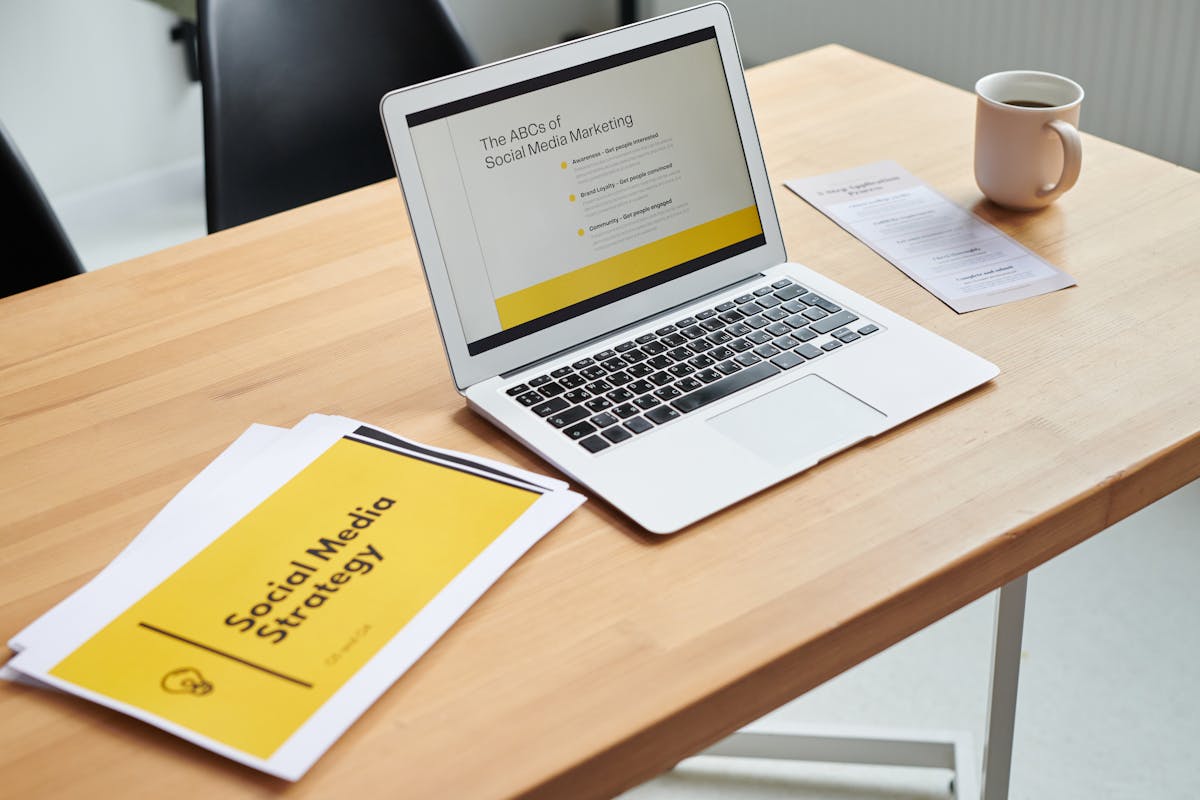 Laptop and printed documents for a social media marketing strategy